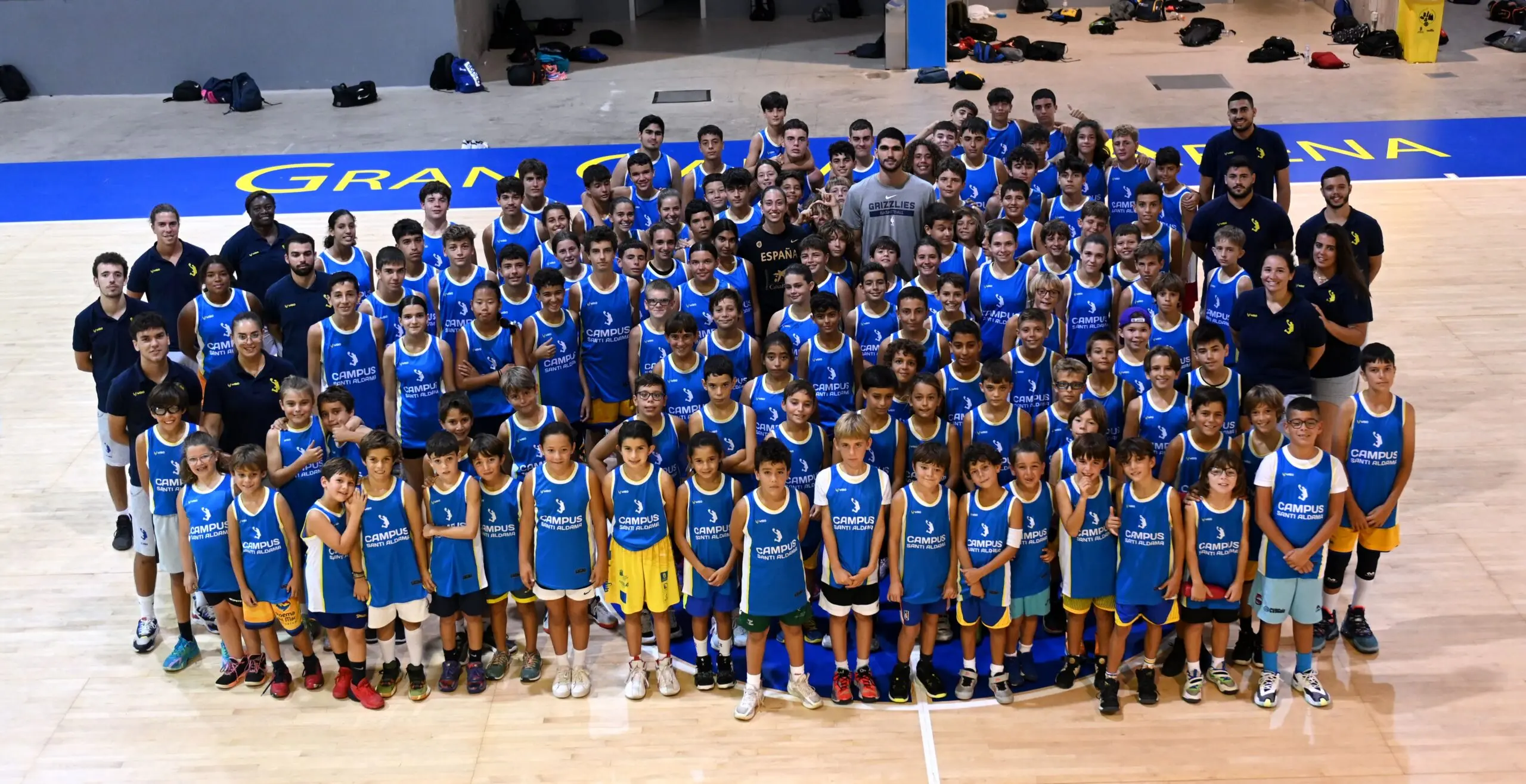 Gran grupo de niños y jóvenes jugadores de baloncesto posando con la equipación oficial azul del Campus Santi Aldama en Las Palmas