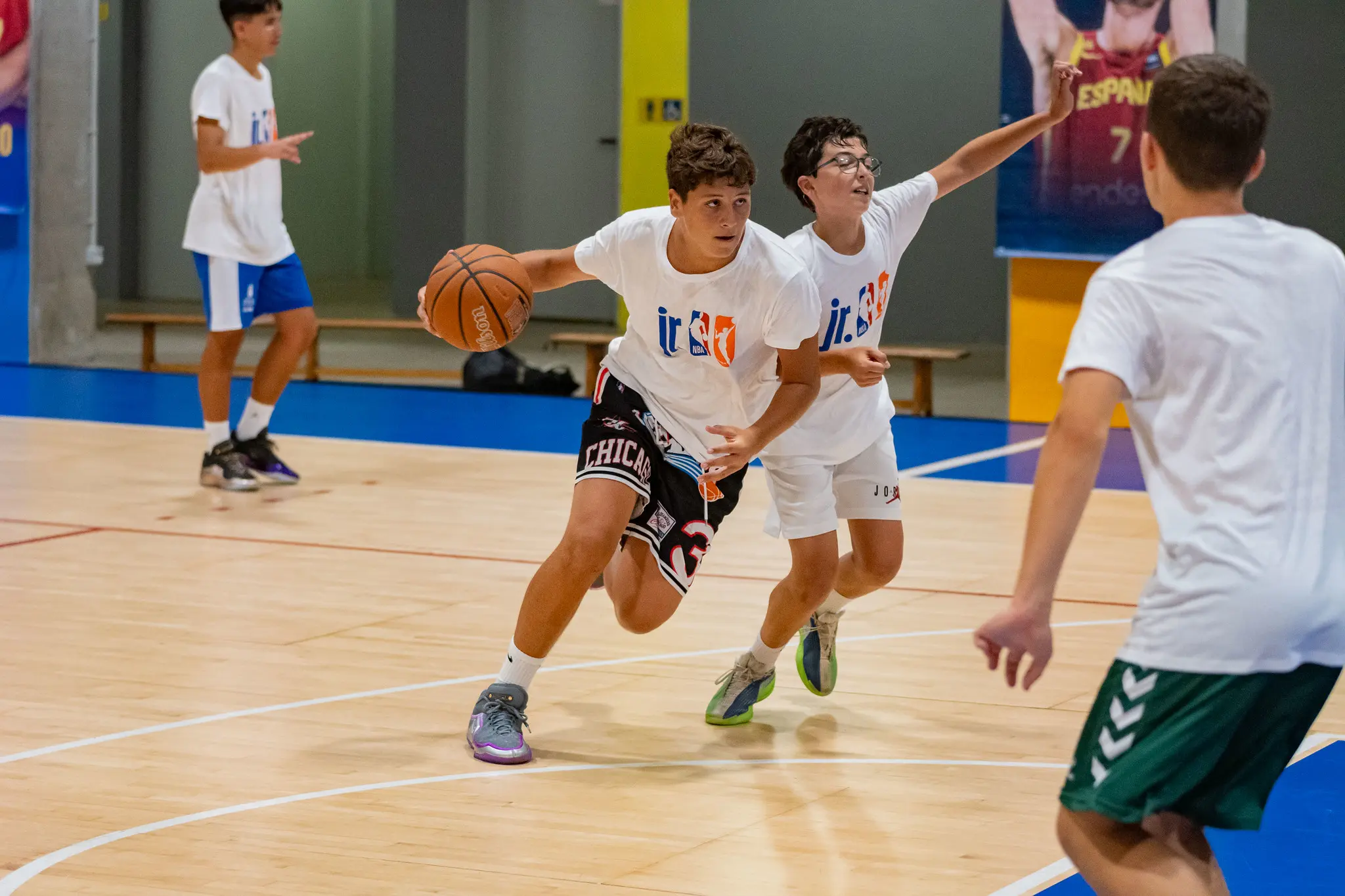 Alumnos del Campus Santi Aldama disputando un partido con las camisetas Jr. NBA en la pista cubierta