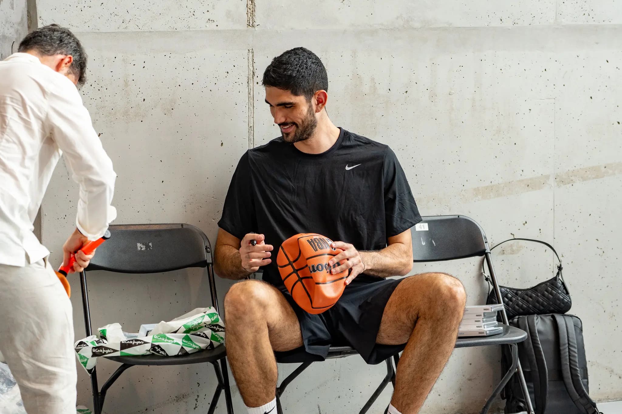 Santi Aldama firmando un balón de la NBA durante su visita al Campus Santi Aldama