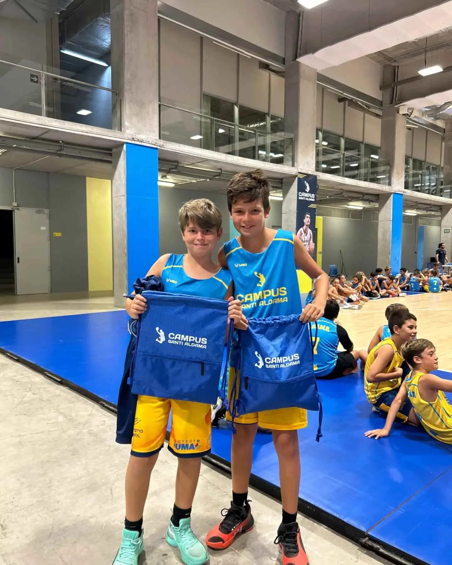 Dos niños del Campus Santi Aldama posando con las equipaciones oficiales en el Gran Canaria Arena