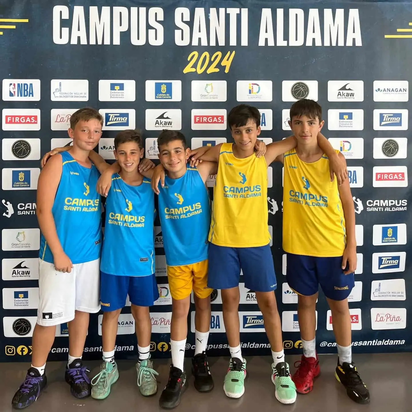 Cinco alumnos del Campus Santi Aldama posando abrazados con las equipaciones oficiales en el Gran Canaria Arena